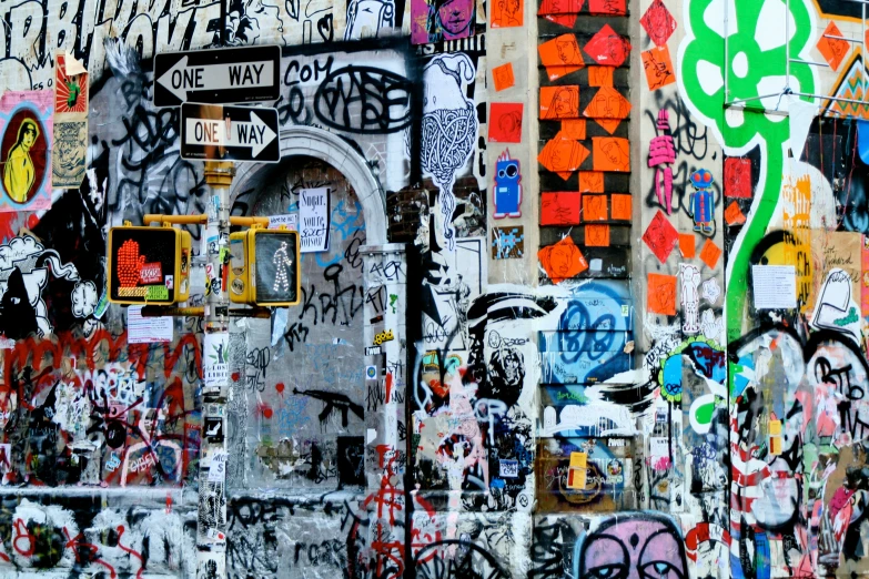 a building wall with lots of graffitti and a traffic signal