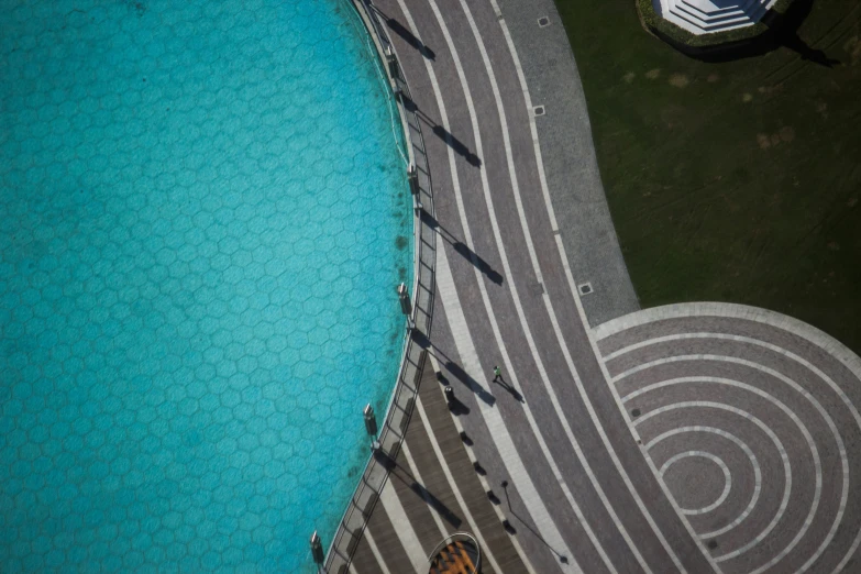 the top view of an aerial view of people walking along the walkway near a pool