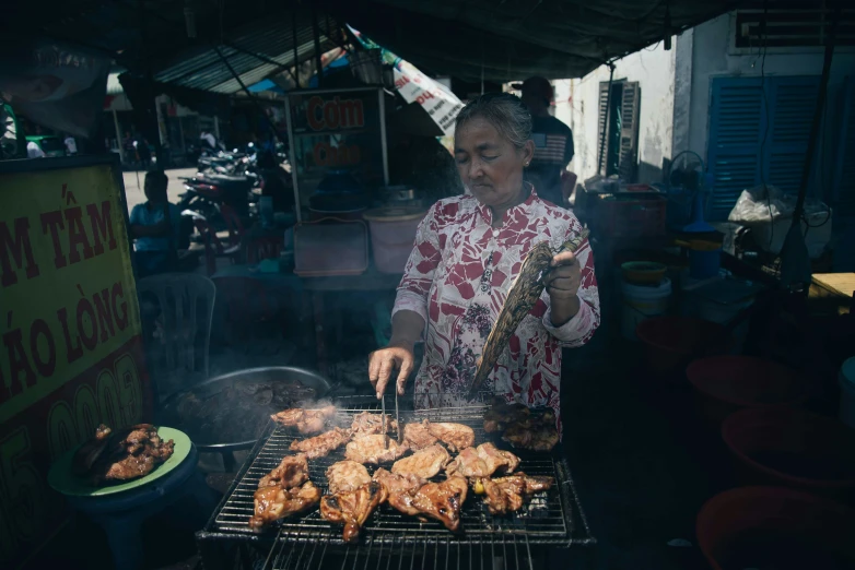 a person cooking food on a grill in a city