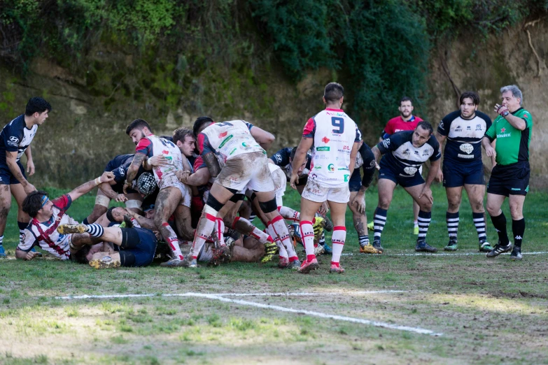 rugby players are huddle together on the ground