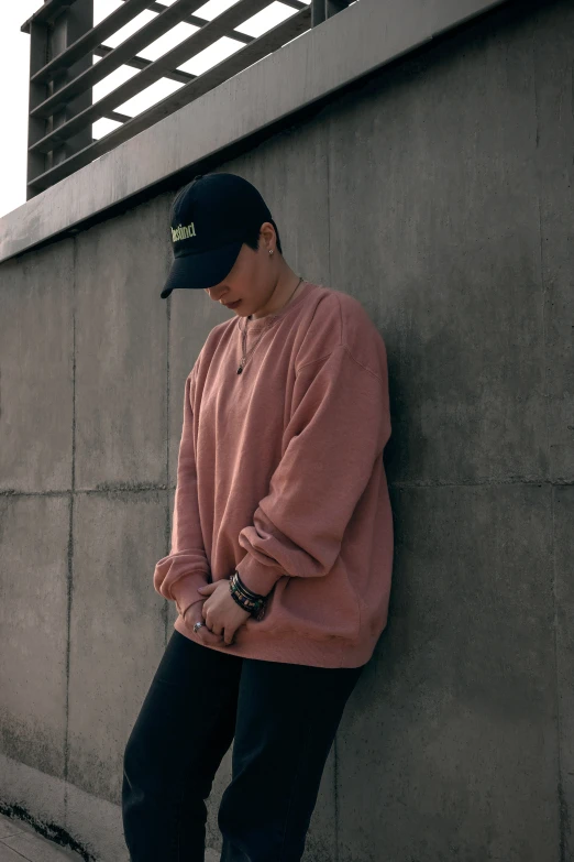 a young man standing on the corner of a cement wall