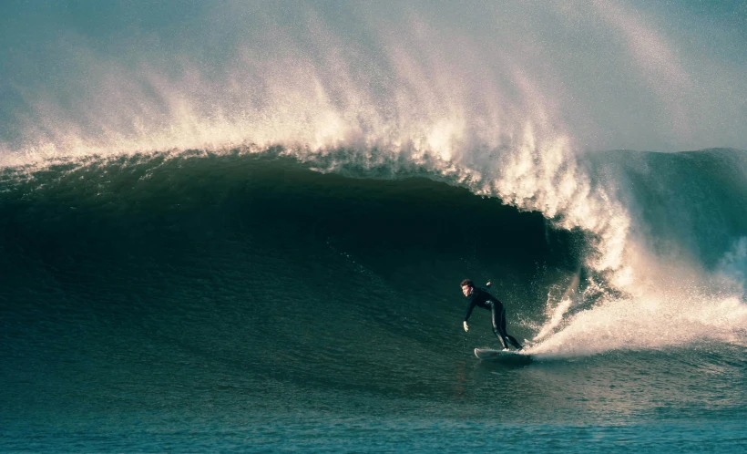 a person on a surf board riding a large wave