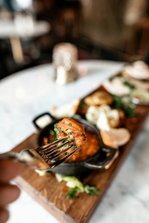 a person is  into a meal on the wooden board