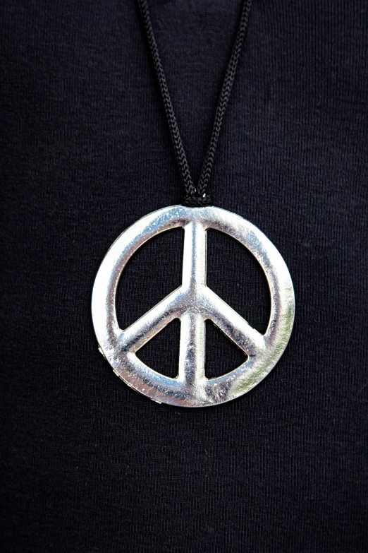 a peace sign pendant on a black chain