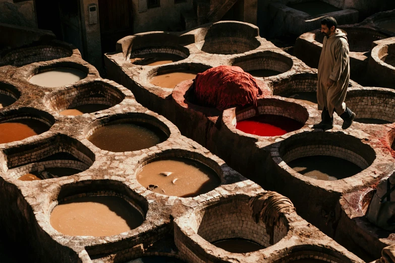 large pots are being filled with red and brown liquid