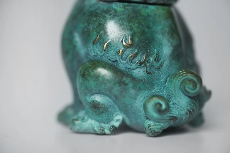 an intricate green pottery vase with a large octo on it