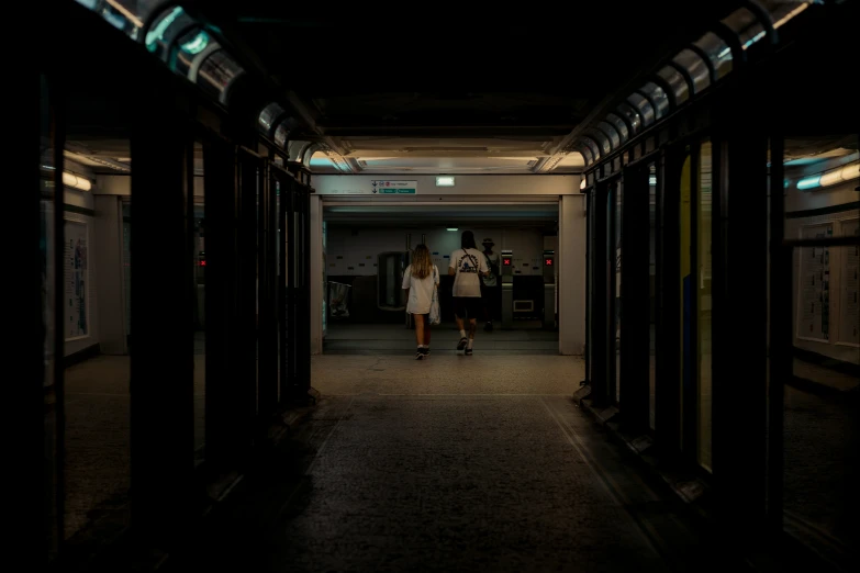 a couple walking down the hallway of a dark building