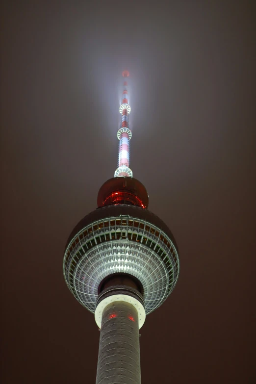 a view of a tower, lit up in red and white