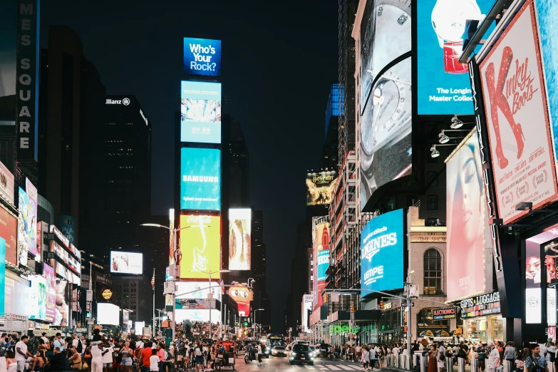 crowded city street with advertits at night