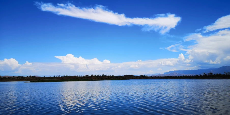 the sun shines on a blue lake