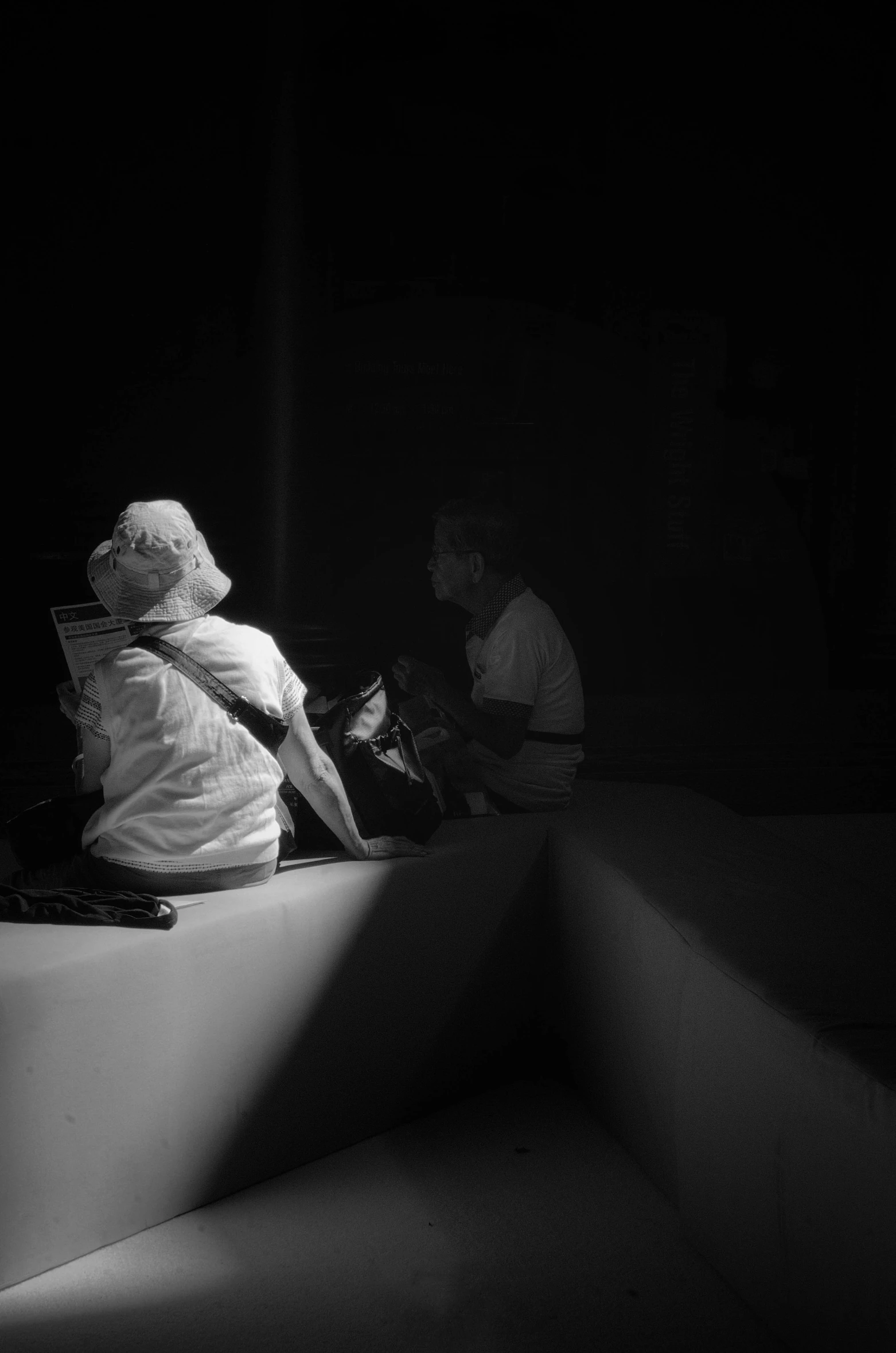 a black and white po with two people on a bench