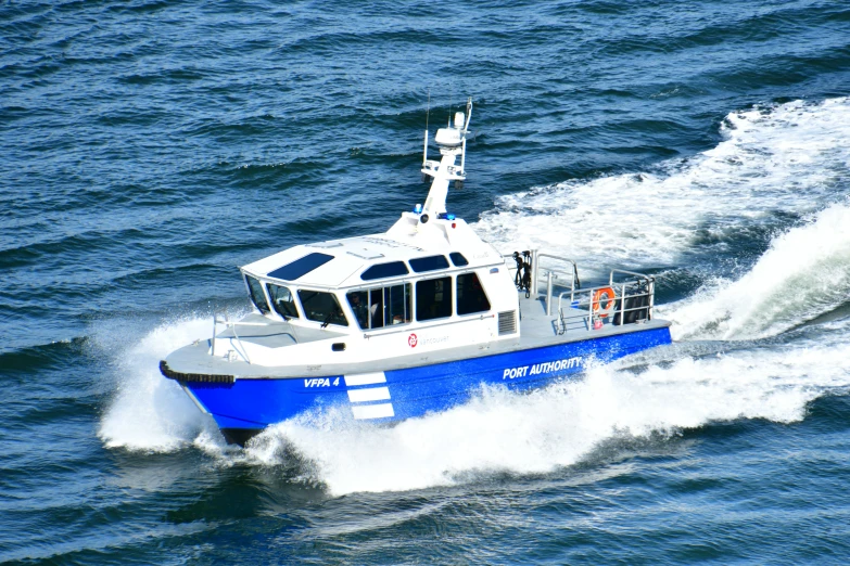a blue and white boat driving on the water