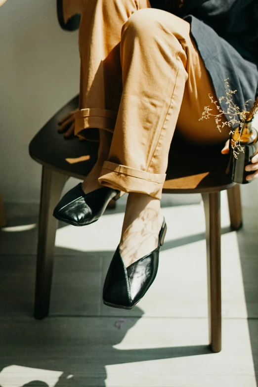 a woman in heels is sitting on a chair