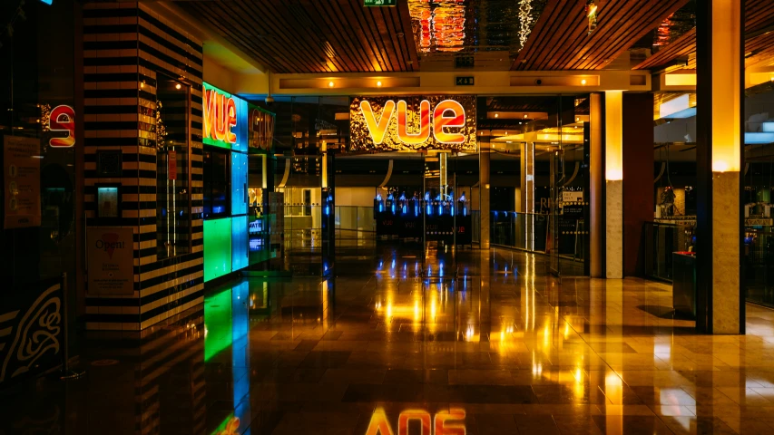 the inside of a building with an entrance that has neon signs