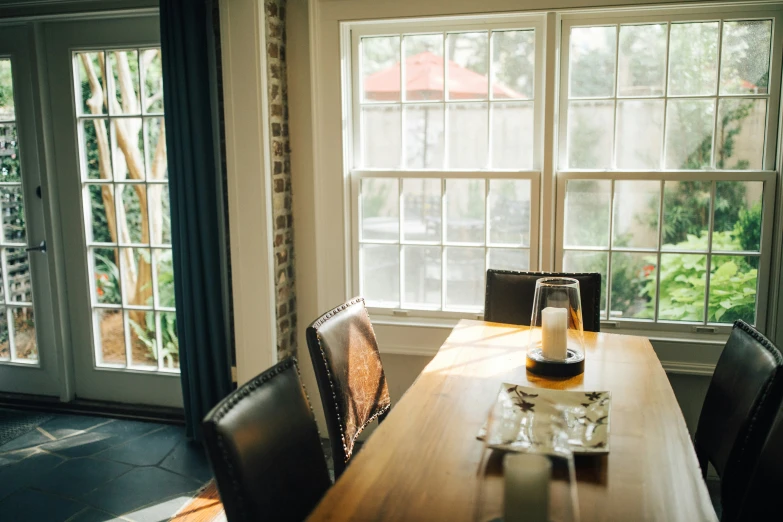 a wooden table is with several chairs and a bottle of beer