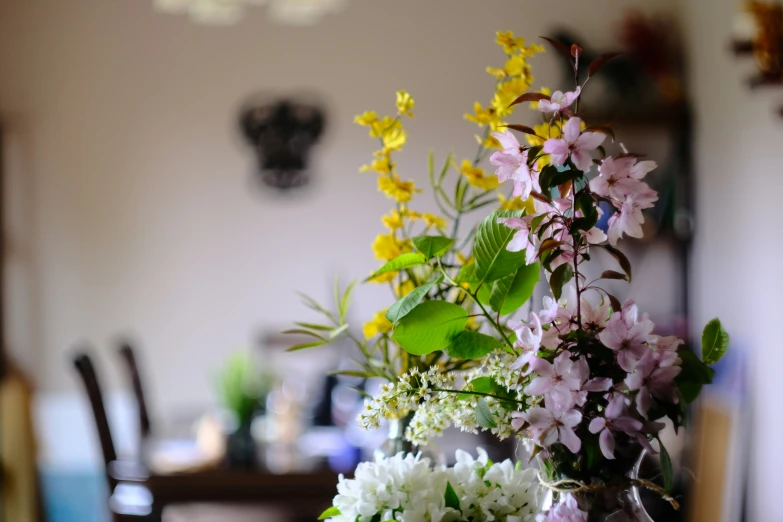 flowers in a vase on top of a wooden table