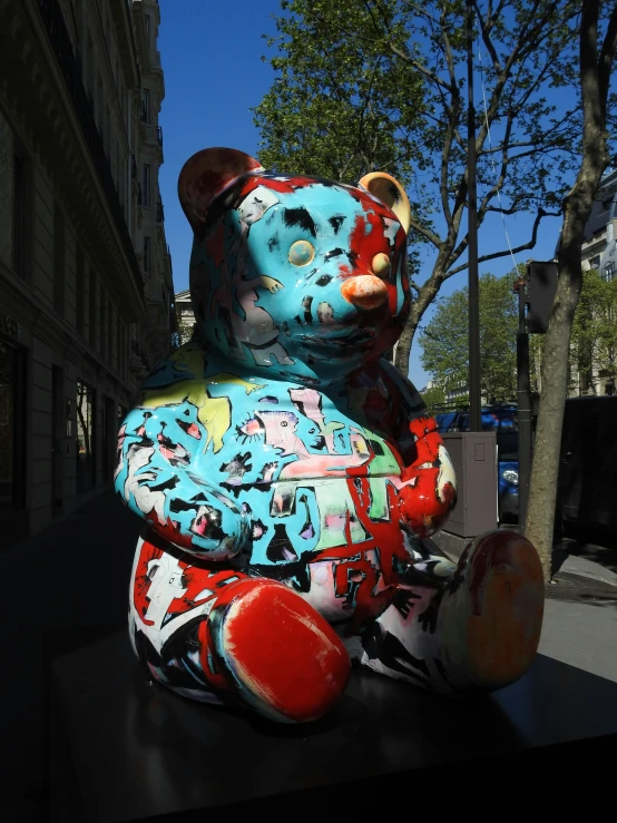 a blue and pink teddy bear that has splattered on its face