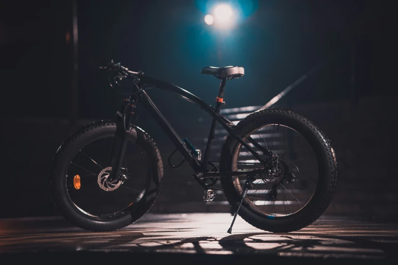 a bicycle is parked on a concrete surface at night