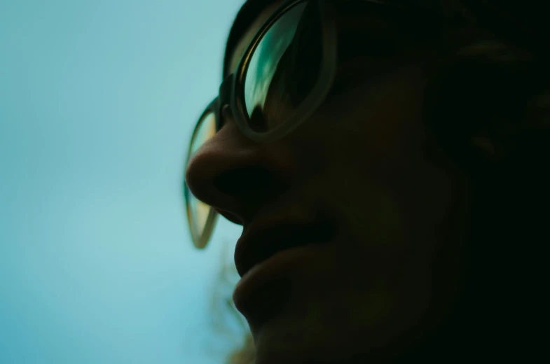 woman with large round glasses staring into the distance