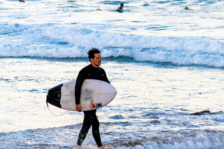 a man with a surf board at the beach