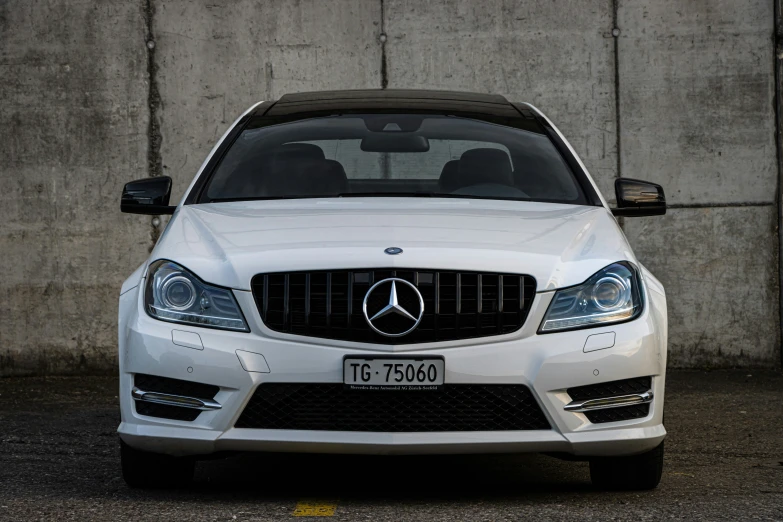 a white mercedes benz is shown from the front