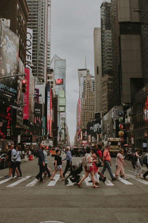 a group of people crossing a busy city street