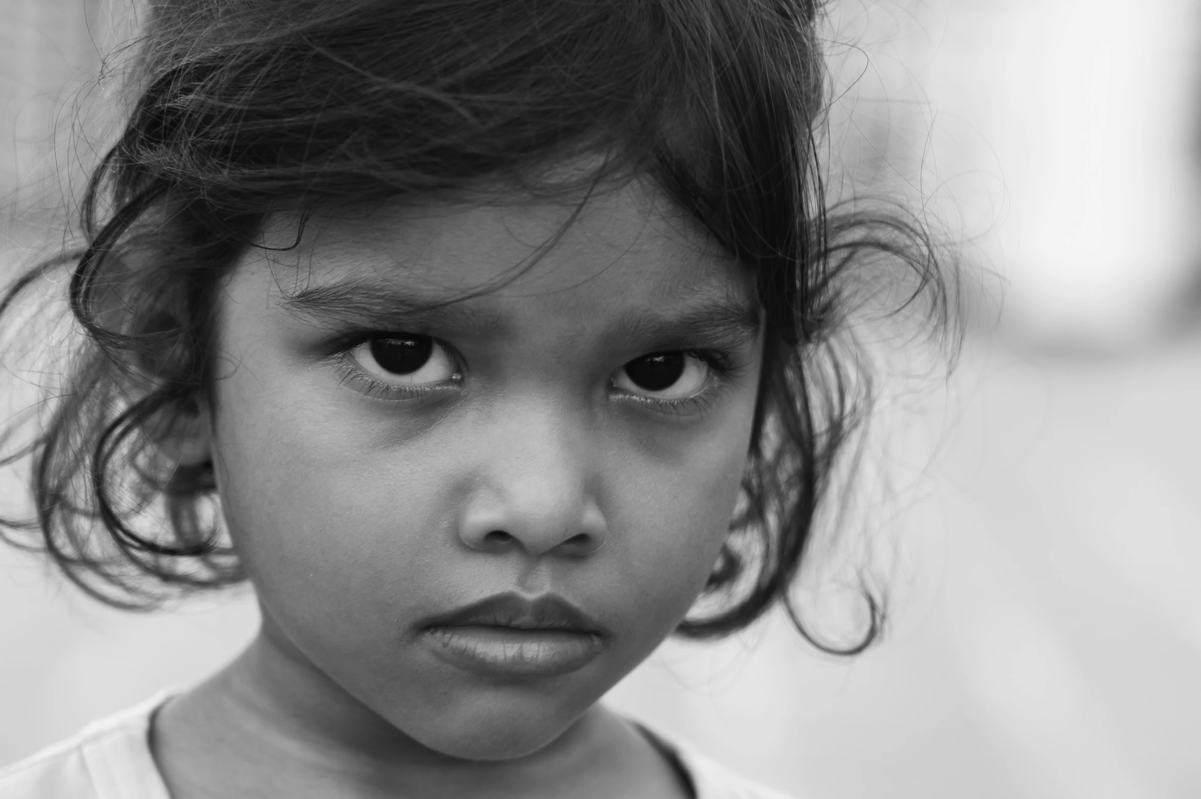 a small girl with long dark hair and an odd face