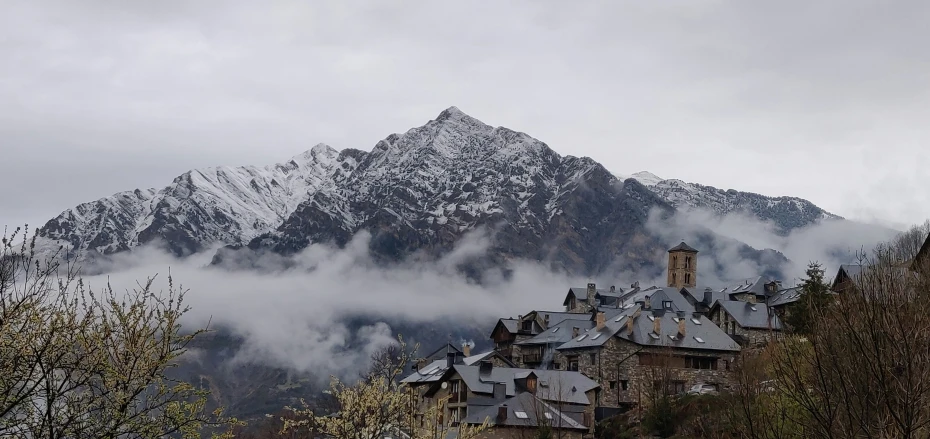 a house sits in the foreground with a mountain behind it