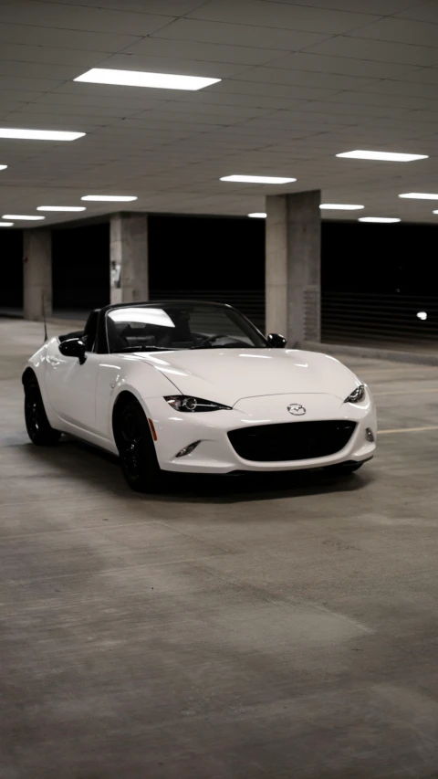 a white sports car parked in a parking lot