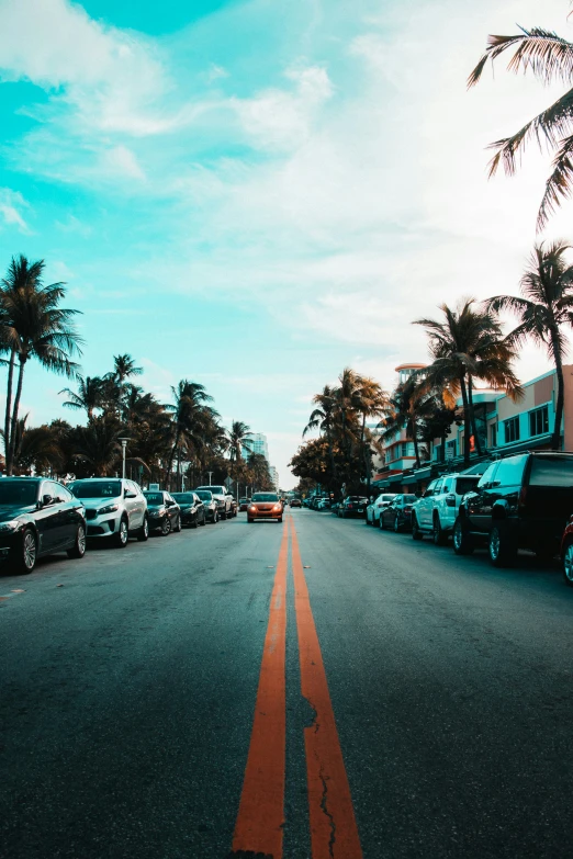 an image of a view down a city street with parked cars