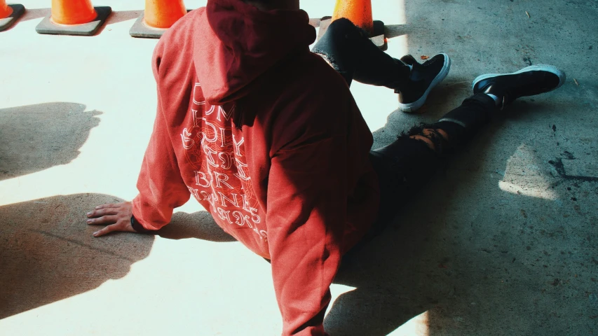 the boy is laying down on the pavement with his skateboard