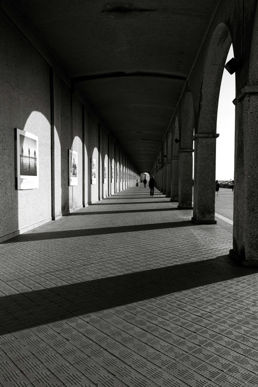 the long hallway is lined with arched windows