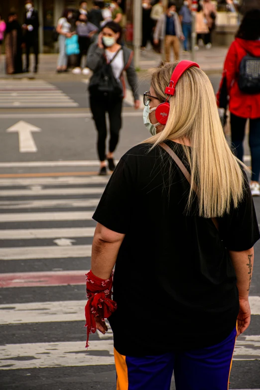 a man with a red bandana standing in the middle of the street