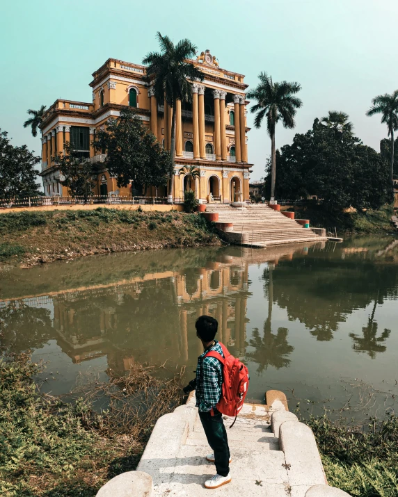 boy with a backpack walks up to a river