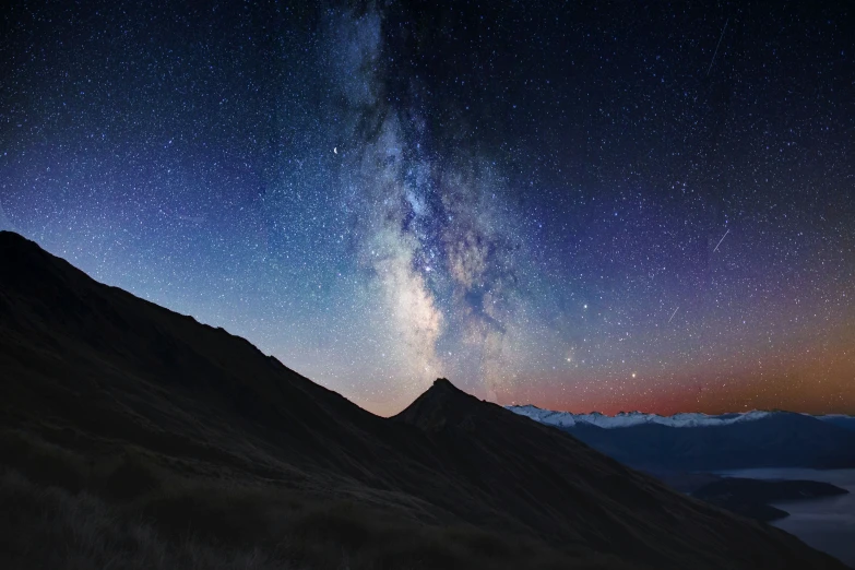 the night sky and stars above a mountain