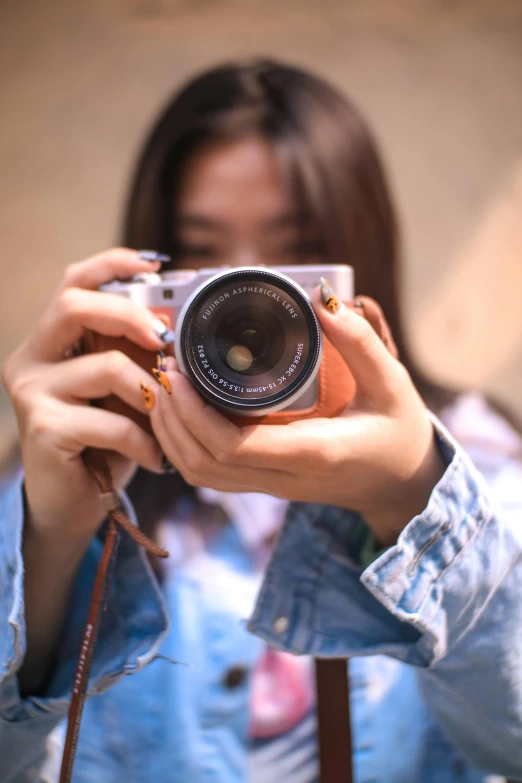 a woman holding up a camera with both hands