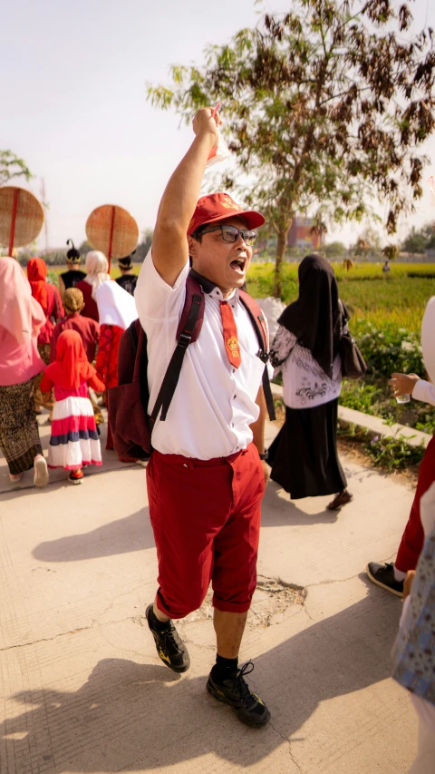 there is a man with a red tie holding a bunch of flowers