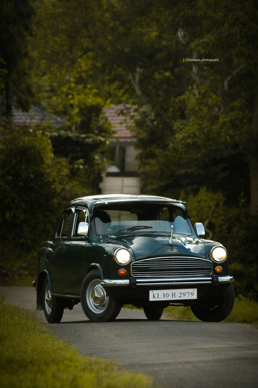 a green car driving on the road through some bushes