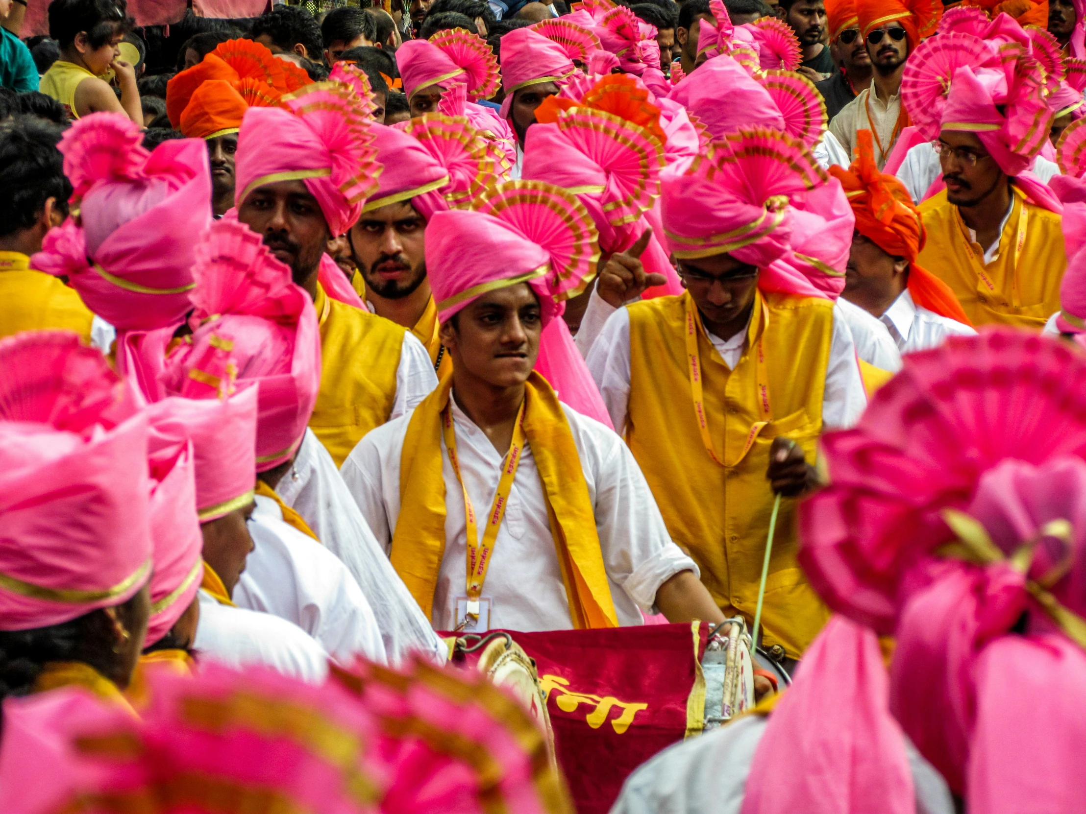 people with colorful turbans sitting in a large crowd