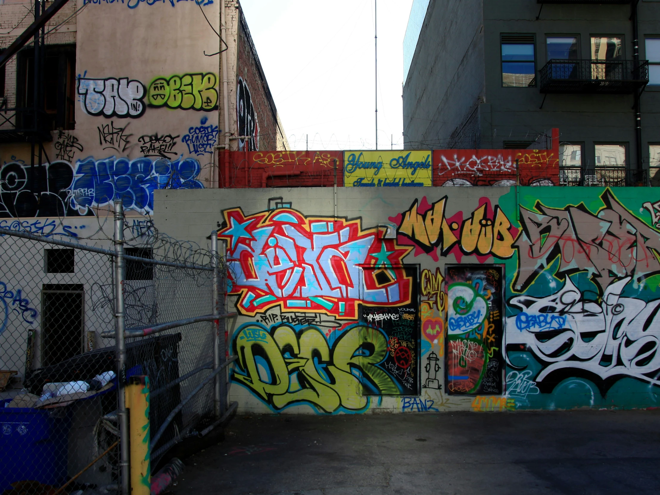 a wall covered in various graffiti and other colorful artwork