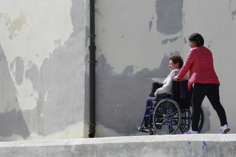 a lady hing a child in a wheelchair