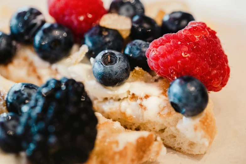 close up image of a plate with blueberries, raspberries, and scones on it