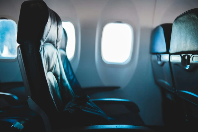 empty seats on an airplane are shown with light reflecting from the window