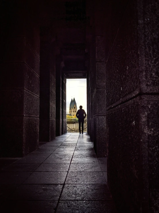 a man standing alone holding an umbrella in the dark