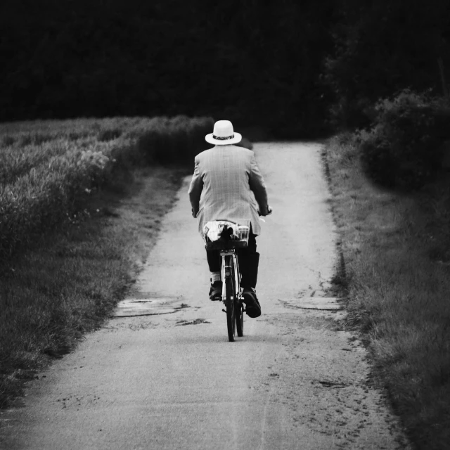 a man riding his bike down the dirt road