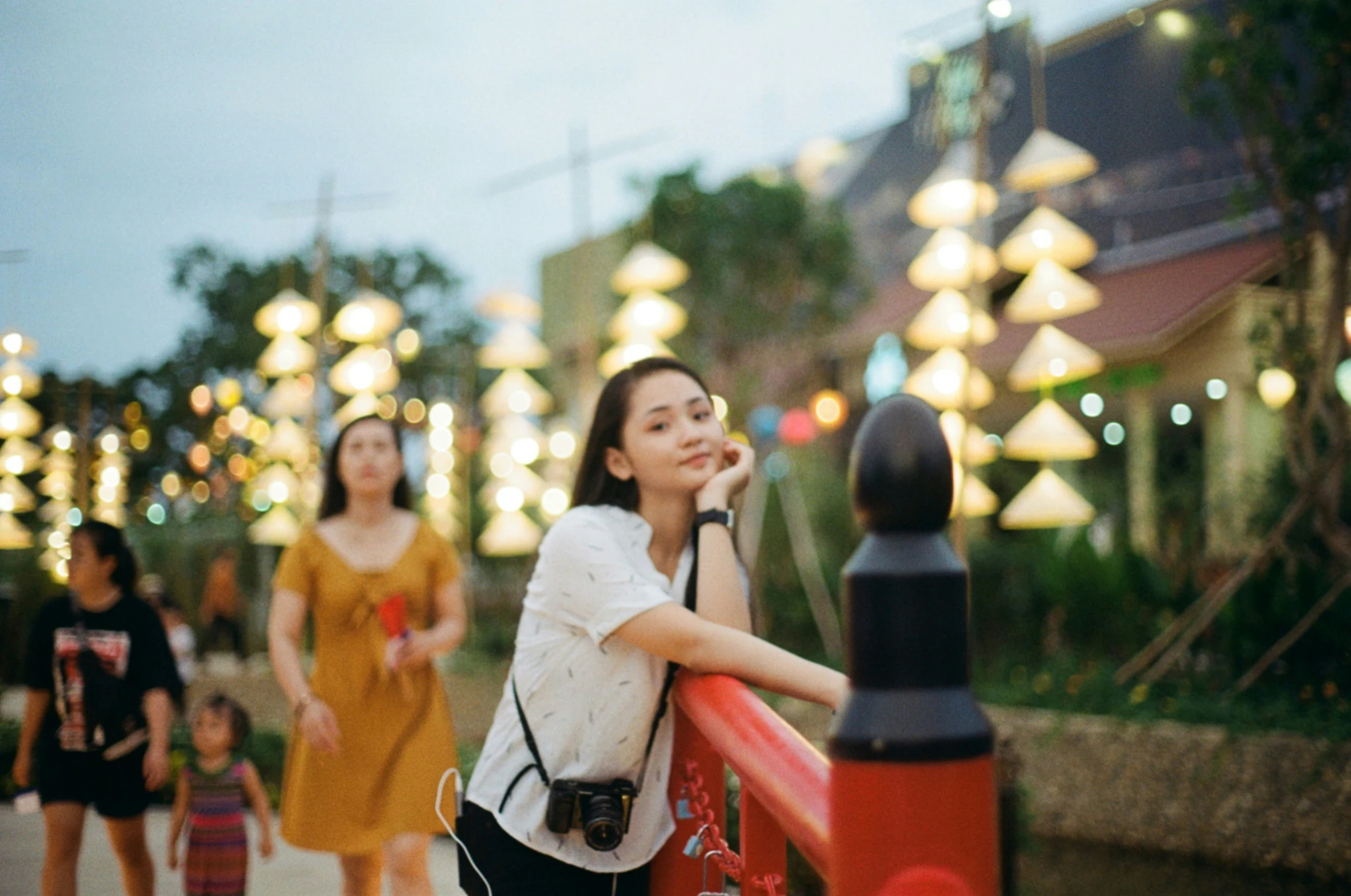 people are walking in a group near a red and black pole