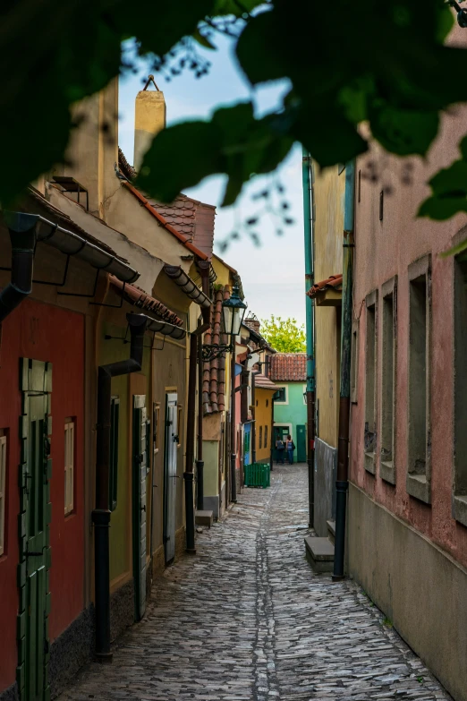 a very narrow alleyway with shops, bars, and buildings