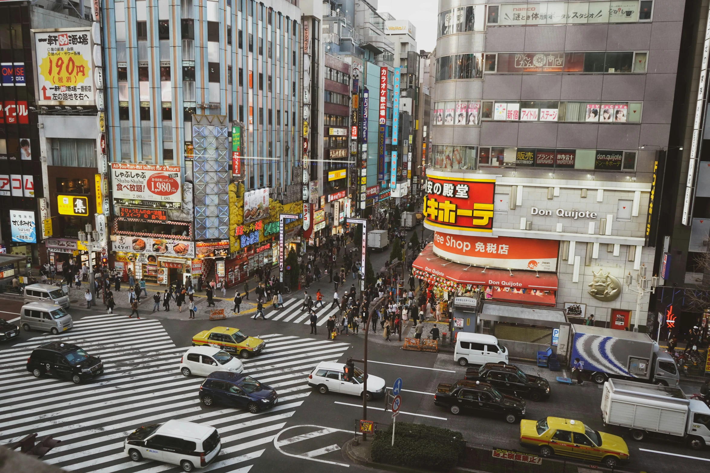 a busy city street with pedestrians, cars and taxis