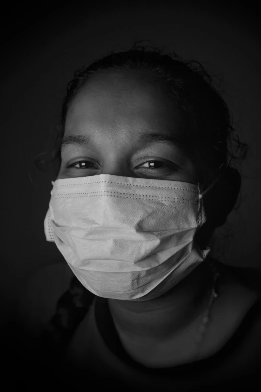 black and white image of a girl wearing a face mask