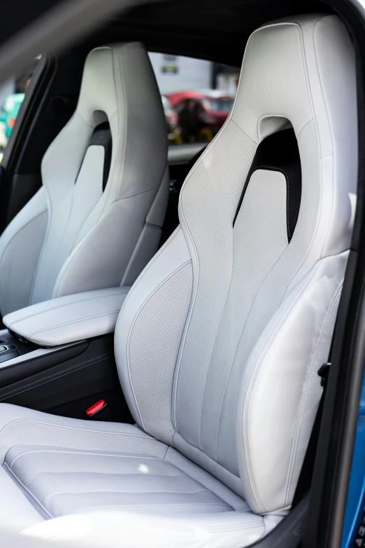 the back seats of a car that has white leather